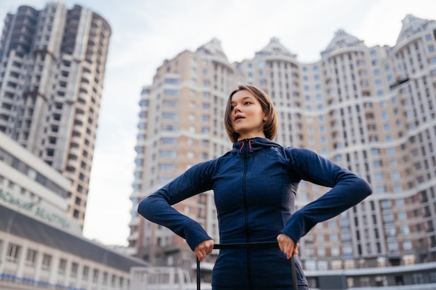 Foto gratuita joven mujer deportiva haciendo ejercicios con goma elástica al aire libre