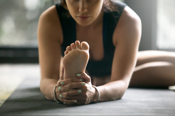 Foto gratuito joven mujer deportiva en janu sirsasana pose, fondo de estudio