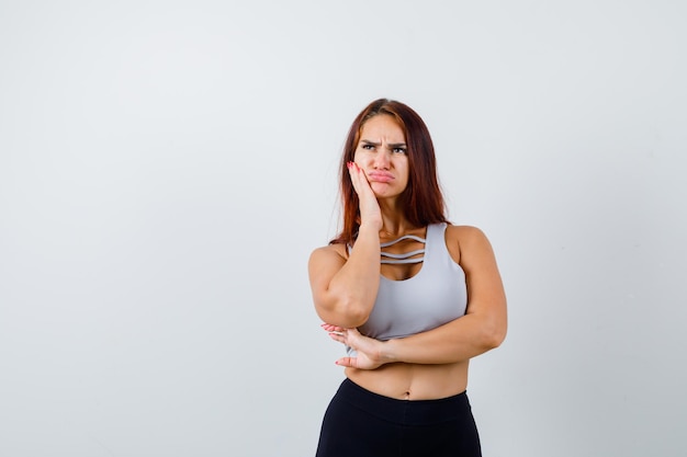 Joven mujer deportiva en un top gris