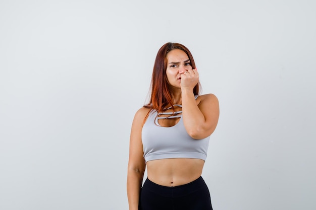 Foto gratuita joven mujer deportiva en un top gris