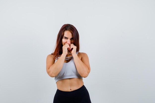 Joven mujer deportiva en un top gris