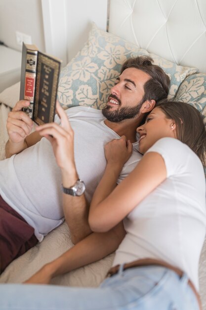 Joven mujer descansando cerca de hombre de lectura