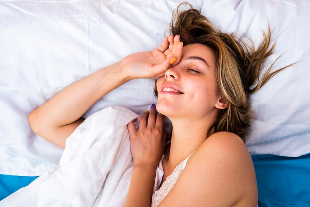 Joven mujer despierta por la mañana