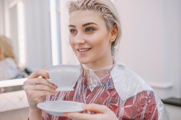 Joven mujer disfrutando de té en el salón