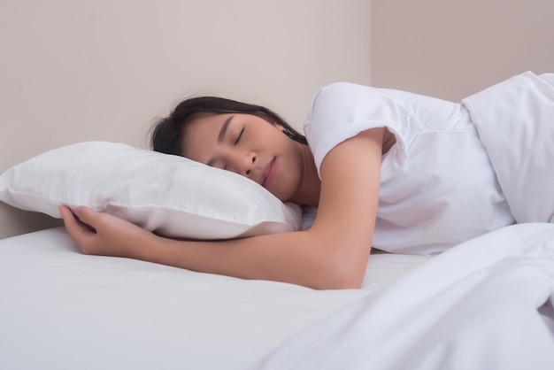 Joven mujer durmiendo en su cama