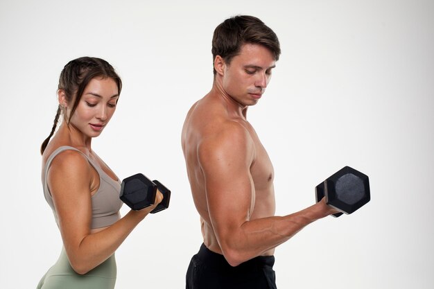 Joven y mujer entrenando juntos para culturismo