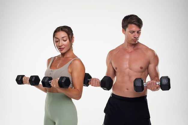 Joven y mujer entrenando juntos para culturismo