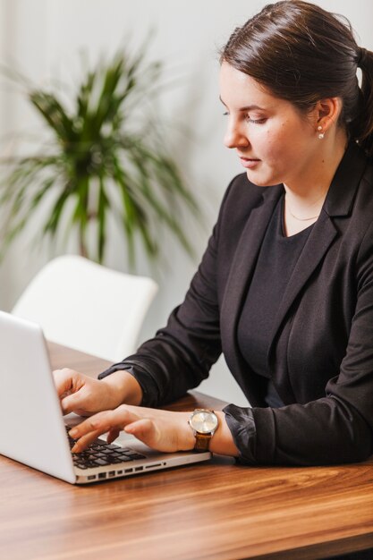 Joven mujer escribiendo portátil