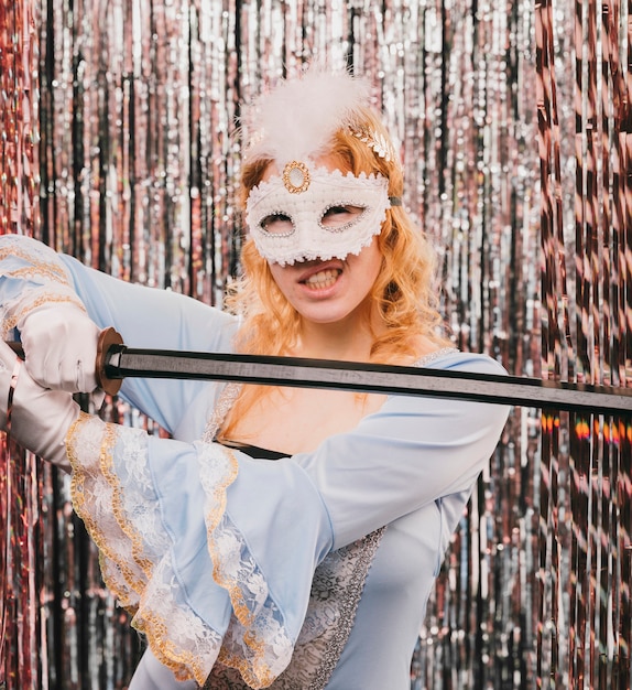 Foto gratuita joven mujer con espada en fiesta de carnaval