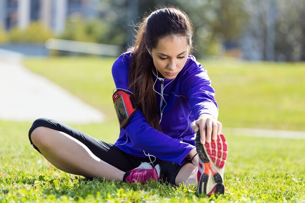 Joven mujer se extiende y se prepara para correr