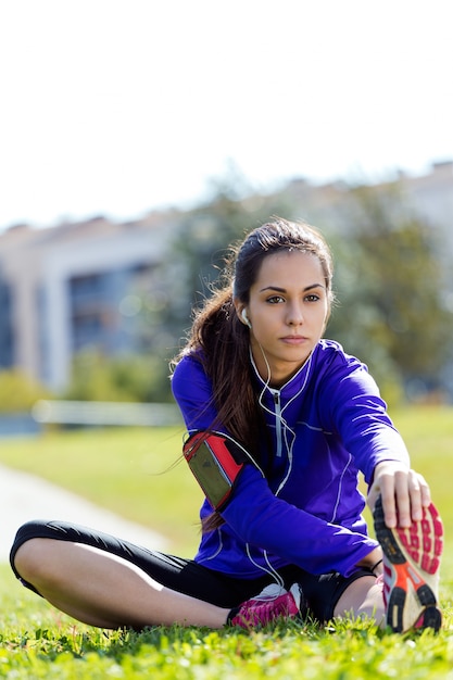 Joven mujer se extiende y se prepara para correr