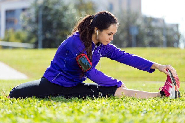 Joven mujer se extiende y se prepara para correr