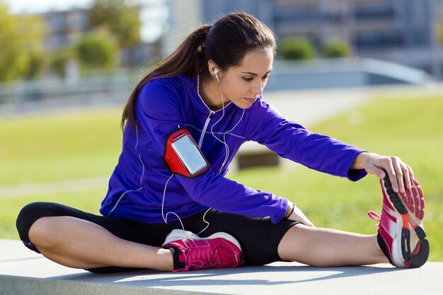 Joven mujer se extiende y se prepara para correr