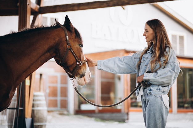 Joven mujer feliz con caballo en el rancho