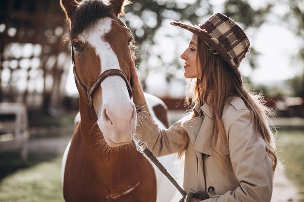 Joven mujer feliz con caballo en el rancho