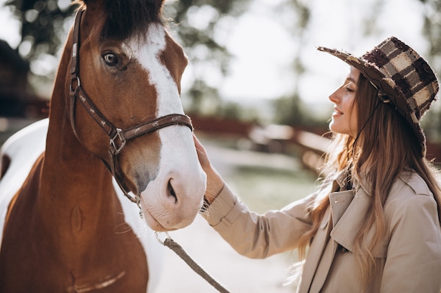 Joven mujer feliz con caballo en el rancho