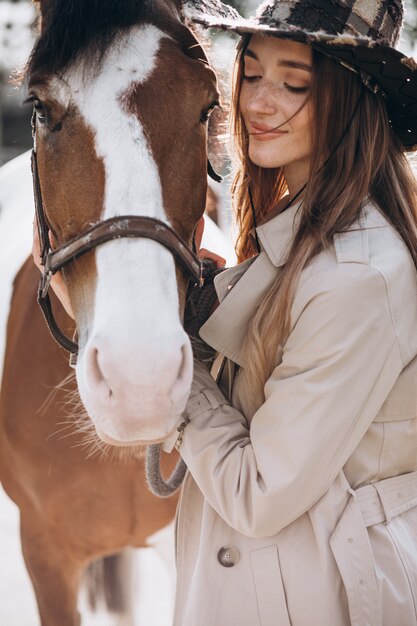 Joven mujer feliz con caballo en el rancho