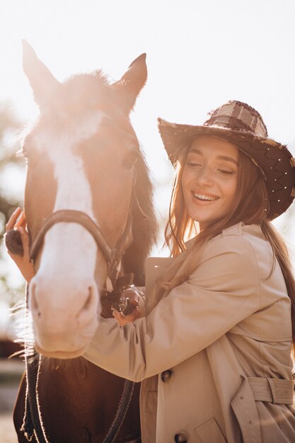 Joven mujer feliz con caballo en el rancho