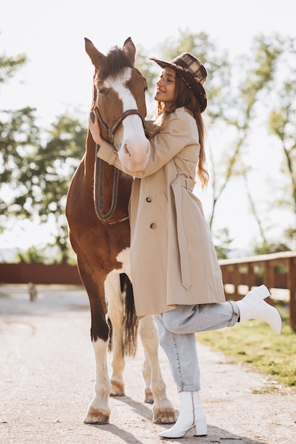 Joven mujer feliz con caballo en el rancho