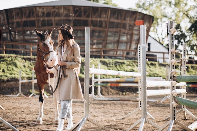 Joven mujer feliz con caballo en el rancho