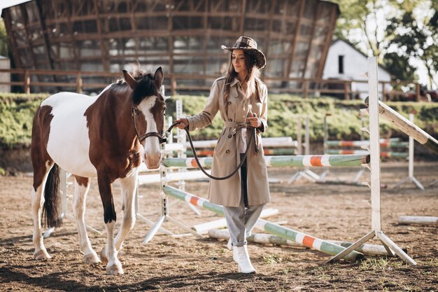 Joven mujer feliz con caballo en el rancho