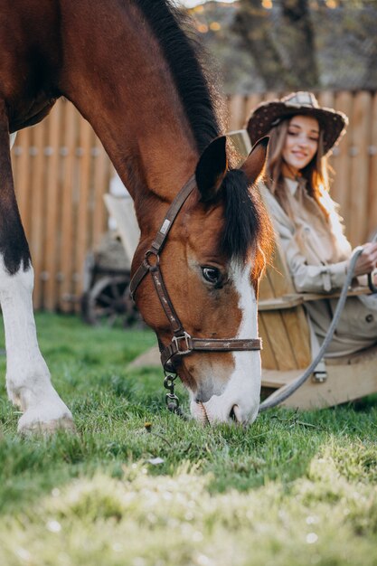 Joven mujer feliz con caballo en el rancho