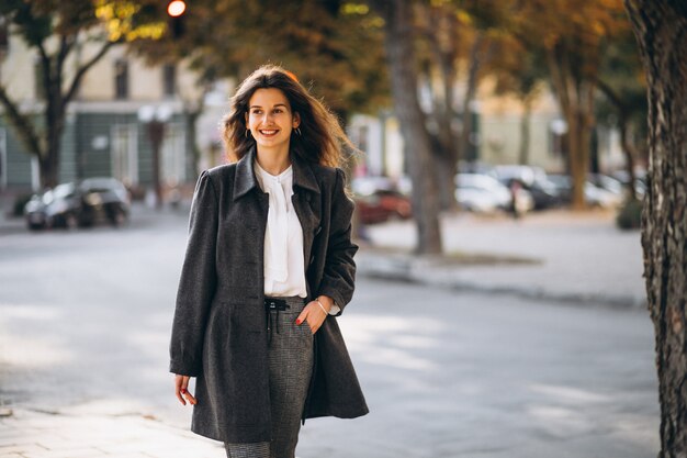 Joven mujer feliz caminando en la calle