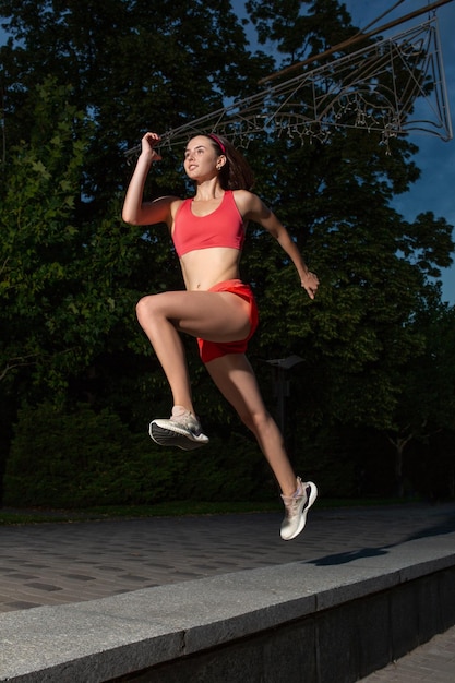 Joven mujer feliz corriendo al aire libre en un parque de la ciudad. Chica corriendo corriendo en la naturaleza para perder peso y mantener una vida saludable. Estilo de vida saludable