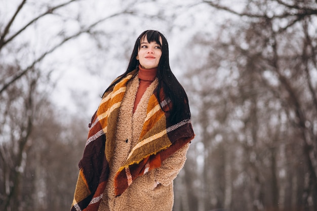 Foto gratuita joven mujer feliz en paños calientes en un parque de invierno