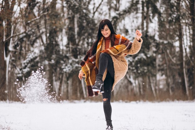 Joven mujer feliz en paños calientes en un parque de invierno