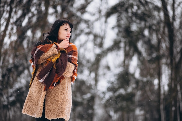 Foto gratuita joven mujer feliz en paños calientes en un parque de invierno