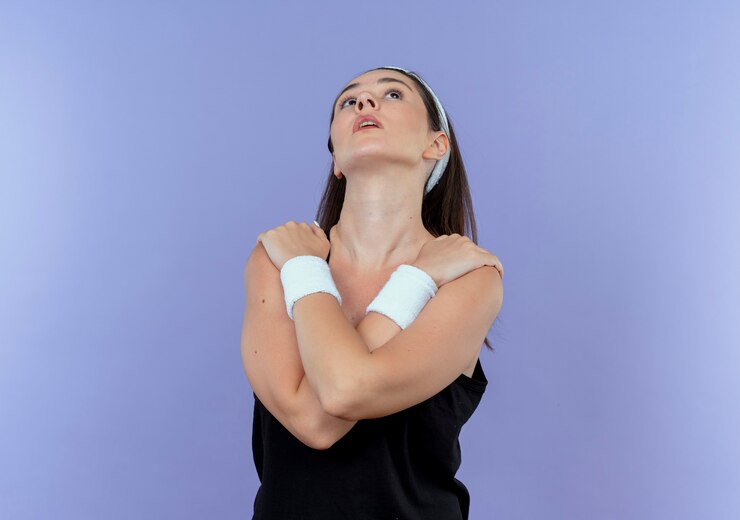 Foto gratuito joven mujer fitness en diadema con aspecto cansado y agotado después del entrenamiento de pie sobre la pared azul