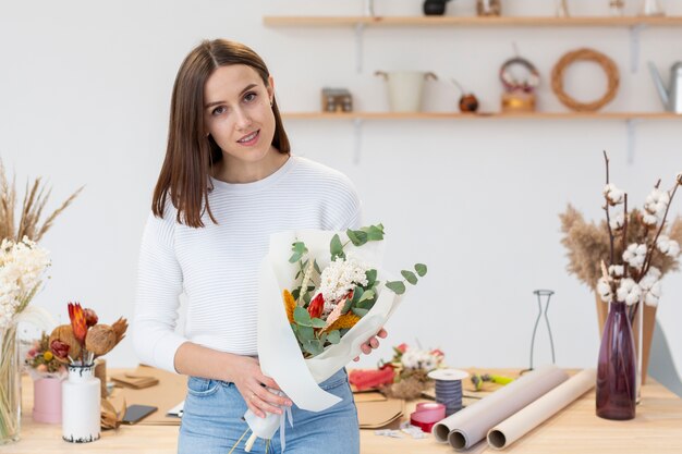 Joven mujer floristería con un ramo