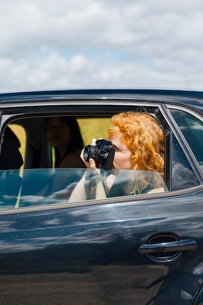 Foto gratuita joven mujer fotografiando en cámara