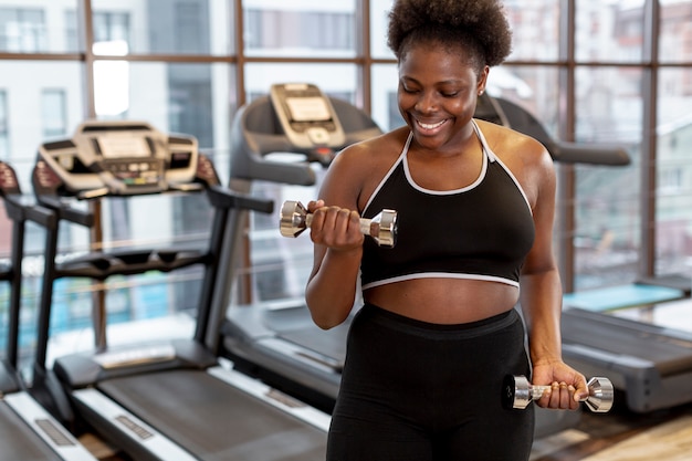 Foto gratuita joven mujer haciendo ejercicio con pesas