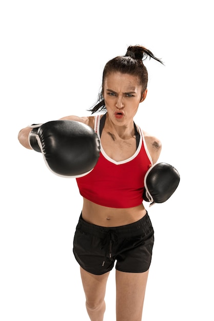Joven mujer hermosa activa con los guantes de boxeo negros boxeo en el estudio aislado sobre fondo blanco. Fitness, concepto de boxeo. Boxeadora. Emociones humanas. Modelo caucásico. energía de golpe de cabeza