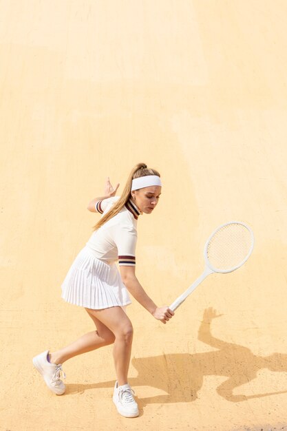Joven mujer jugando tenis en campo