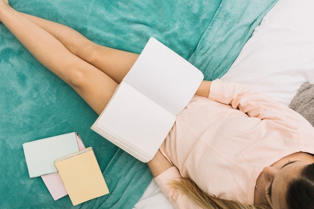 Foto gratuita joven mujer leyendo en la cama