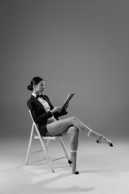 Joven mujer de moda y elegante con chaqueta y calcetines trabajando desde casa.