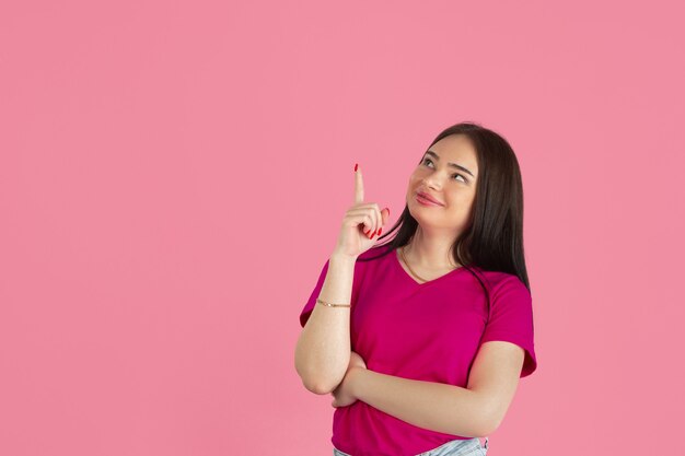 Joven mujer morena caucásica en pared rosa