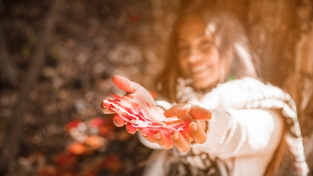 Joven mujer mostrando hojas de otoño