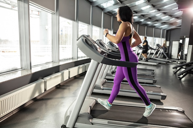 Joven mujer musculosa practicando en el gimnasio con cardio