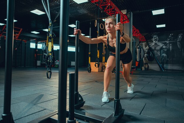 Joven mujer musculosa practicando en el gimnasio