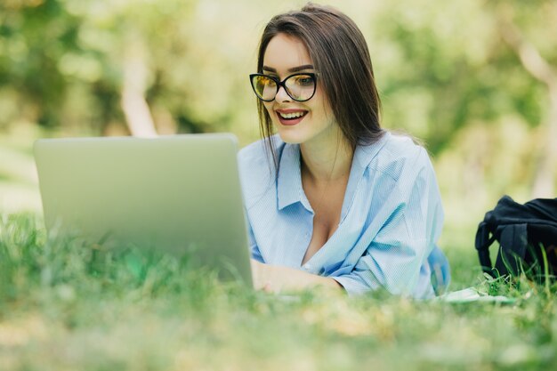Joven mujer muy sonriente con laptop en citypark en día soleado