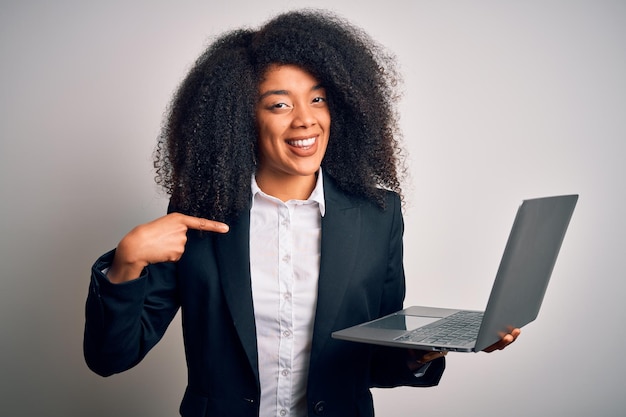 Foto gratuita joven mujer de negocios afroamericana con cabello afro usando computadora portátil del trabajo con cara sorpresa apuntándose a sí mismo