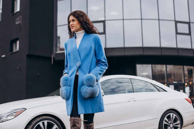 Joven mujer de negocios feliz saliendo de su coche