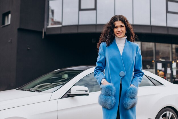 Joven mujer de negocios feliz saliendo de su coche