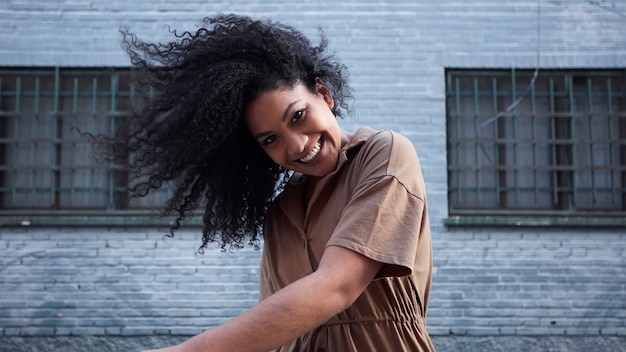 Foto gratuita joven mujer negra con cabello afro riendo y disfrutando