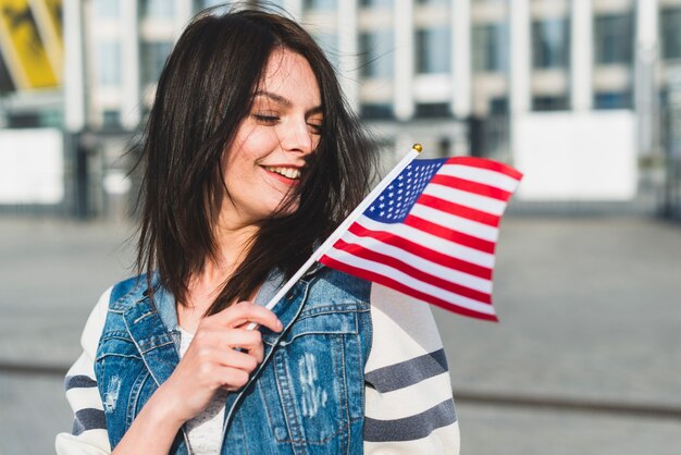 Joven mujer ondeando bandera de Estados Unidos el cuatro de julio