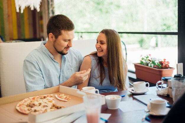 Joven y mujer pasar tiempo juntos en pizzería